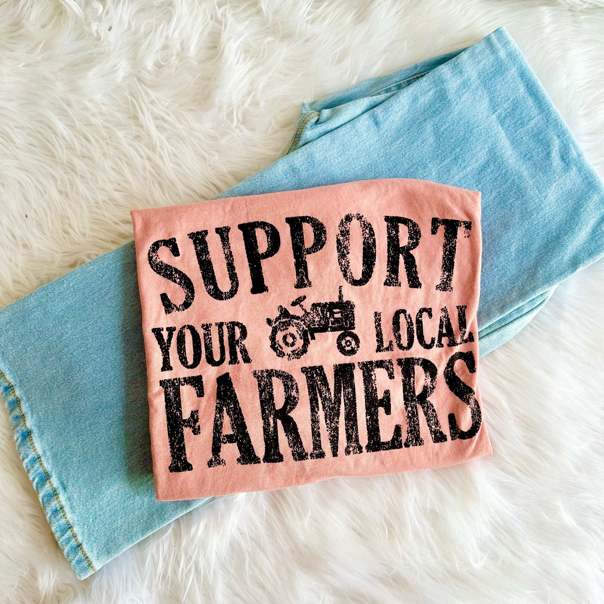 Mauve tee with 'Support Your Local Farmers' text on a denim fabric background