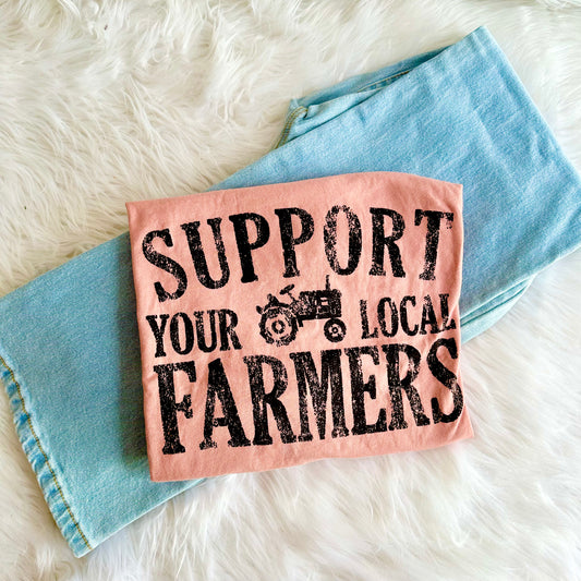Mauve tee with 'Support Your Local Farmers' text on a denim fabric background